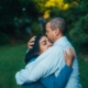 A Black couple hugging outdoors.