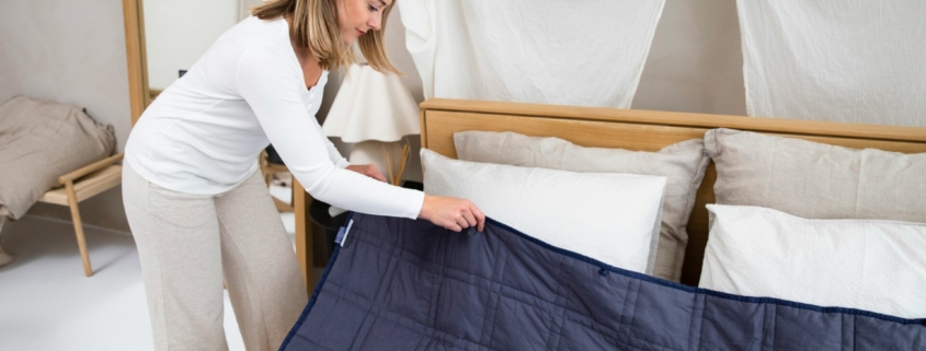 A white woman making a bed.