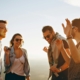 A group of 4 people smiling and standing in a circle outside.