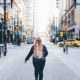 A woman walking down a city street, from behind.