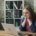 A white woman sitting in front of a laptop at a table, with her head in her hands looking stressed.