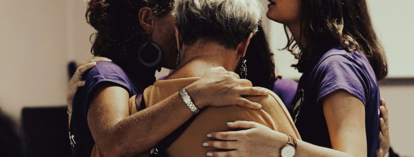 A group of South Asian women of different ages embracing.