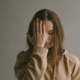 A white woman with her hand on her forehead, looking frustrated.