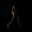 A person in the shadows holding their face in the dark.