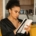A Black woman thoughtfully writing in a notebook while sitting on a couch.
