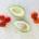 Tomatoes and an avocado on a countertop from above.