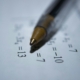 A close up of a math worksheet with a pen laying on top.