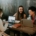 A group of young adults working on laptops at a table in a cafe.