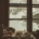 A view of a winter storm through a window, in front of which there is a cozy table with dishes from a meal.