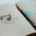 An open journal showing a drawing of a wave on one page and writing on the other.