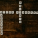 Scrabble tiles arranged to spell out the words 'eating disorder' horizontally and 'anoriexia' and 'bulimia' vertically on a dark wood surface.