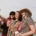 A group of middle aged women taking a selfie outside while holding coffee.