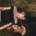two women laying on grass outside on their backs, with their heads turned looking at each other.