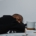 A young man asleep with a book and coffee mug next to him.