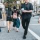 A busy street crosswalk in a city, full of people crossing the street.