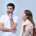 A man and a woman in front of a light blue background looking frustrated.