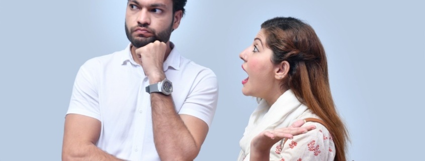 A man and a woman in front of a light blue background looking frustrated.